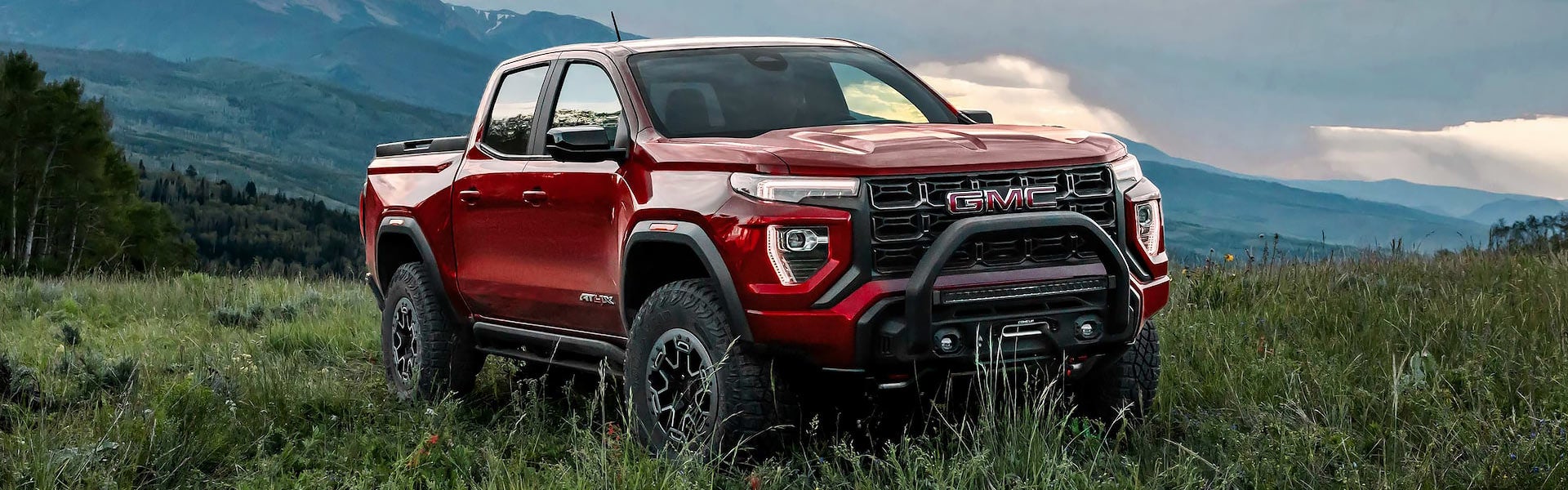 A silver truck sitting parked off-road.