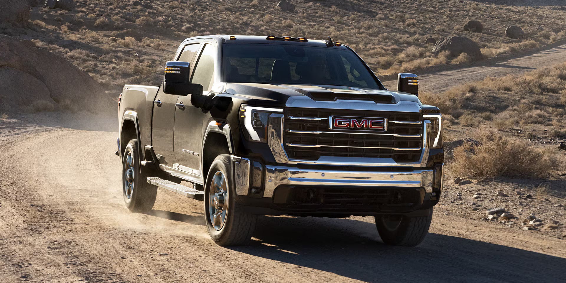 A black truck driving off-road.