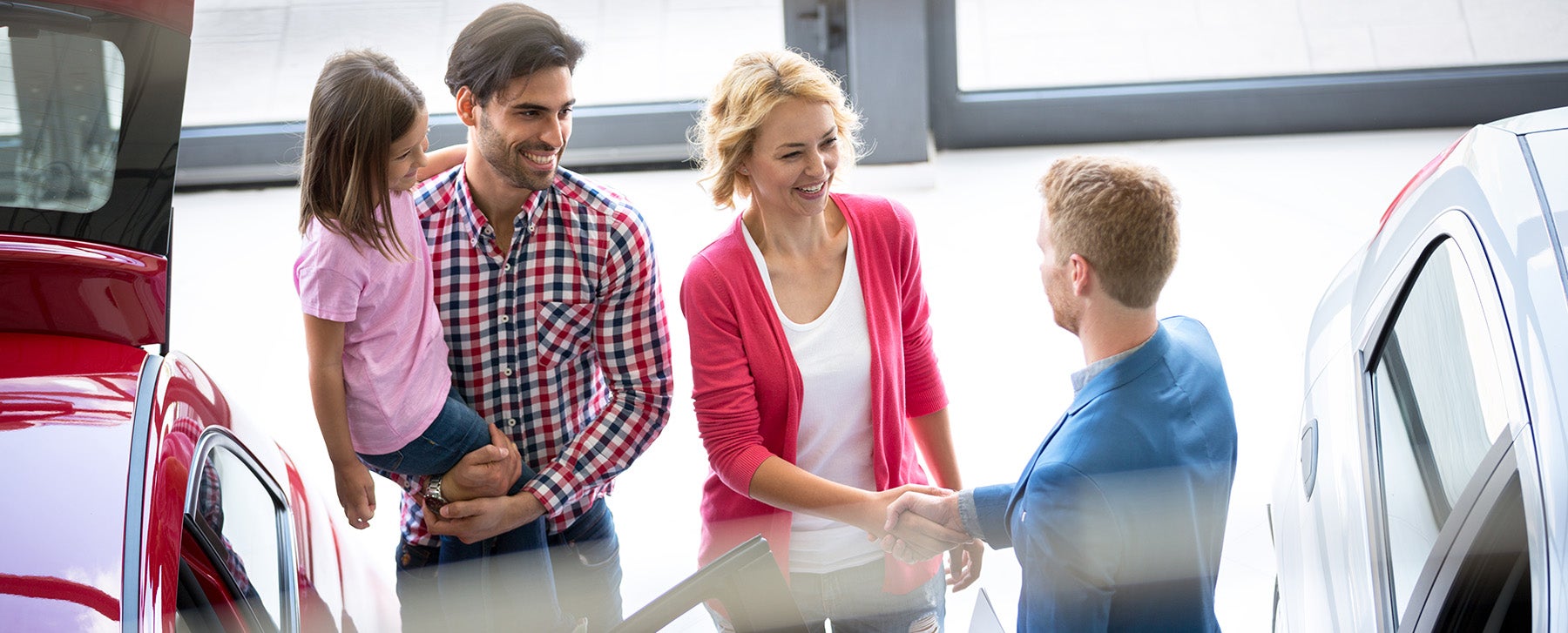 a family at a dealership going over finances with a salesman